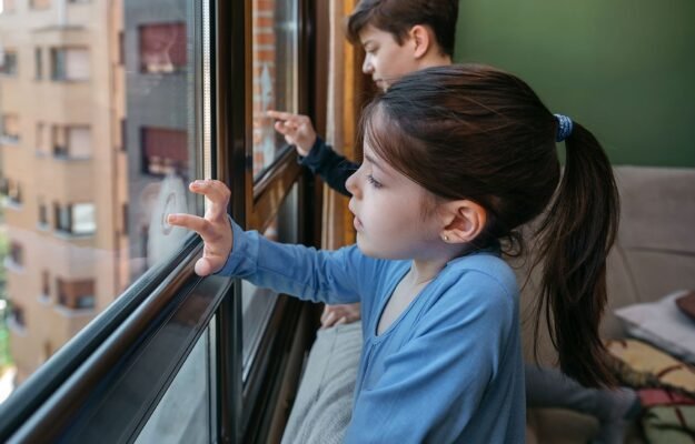 Niños jugando en la ventana