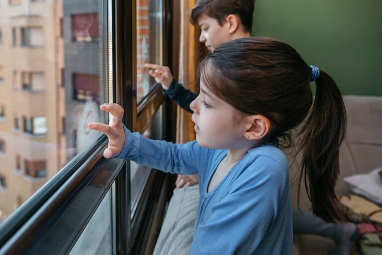 Niños jugando en la ventana